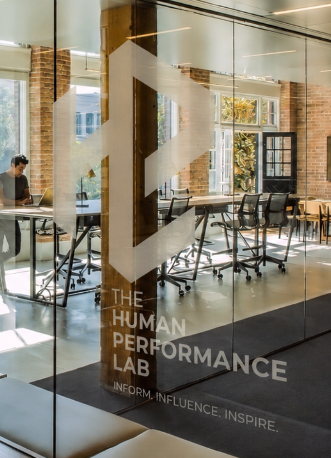 The Human Performance Lab geometric monogram and stacked wordmark on glass, with the line Inform. Influence. Inspire.